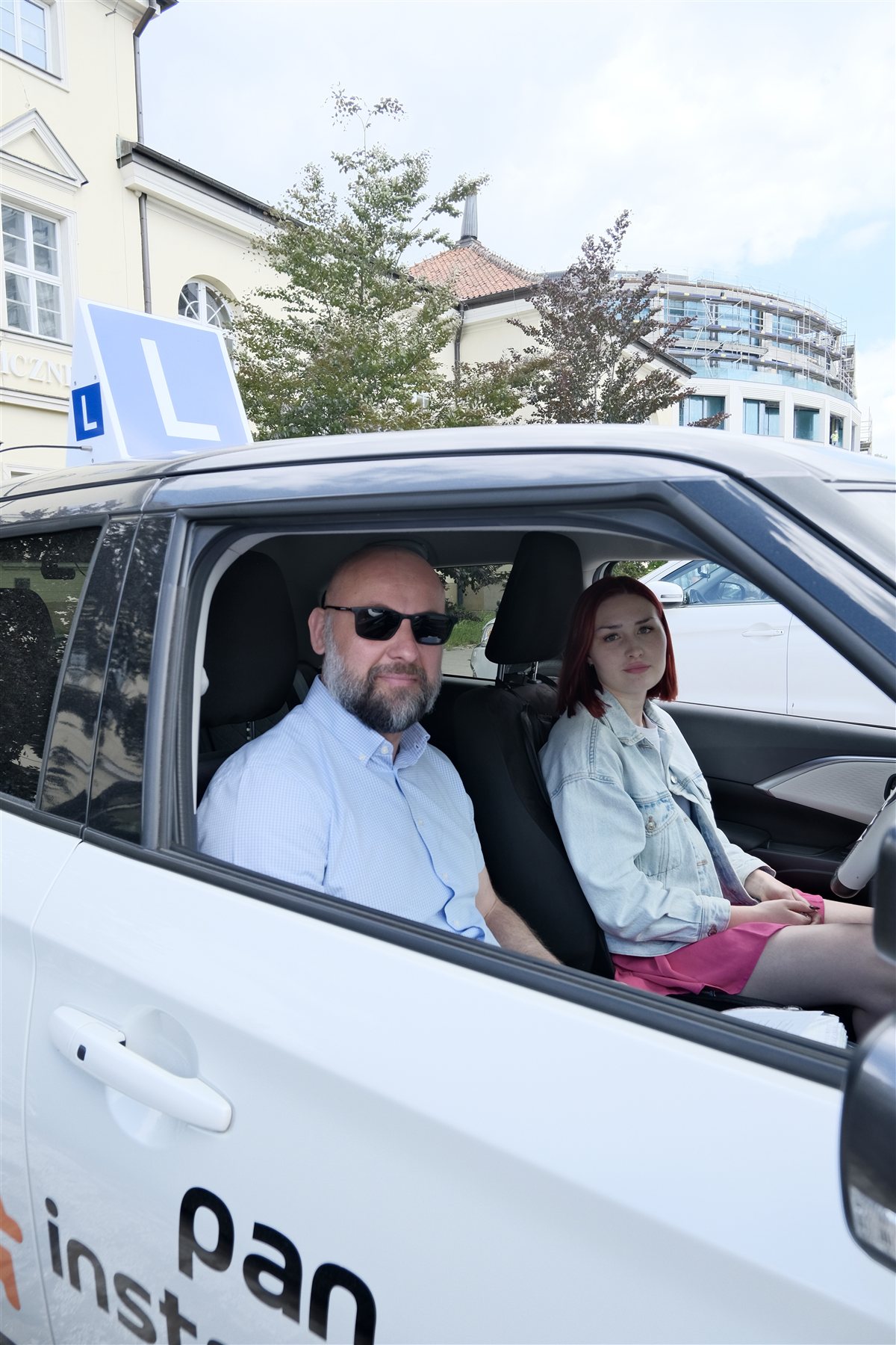 Instruktor i kursantka w samochodzie szkoleniowym — szkoła jazdy Warszawa Śródmieście