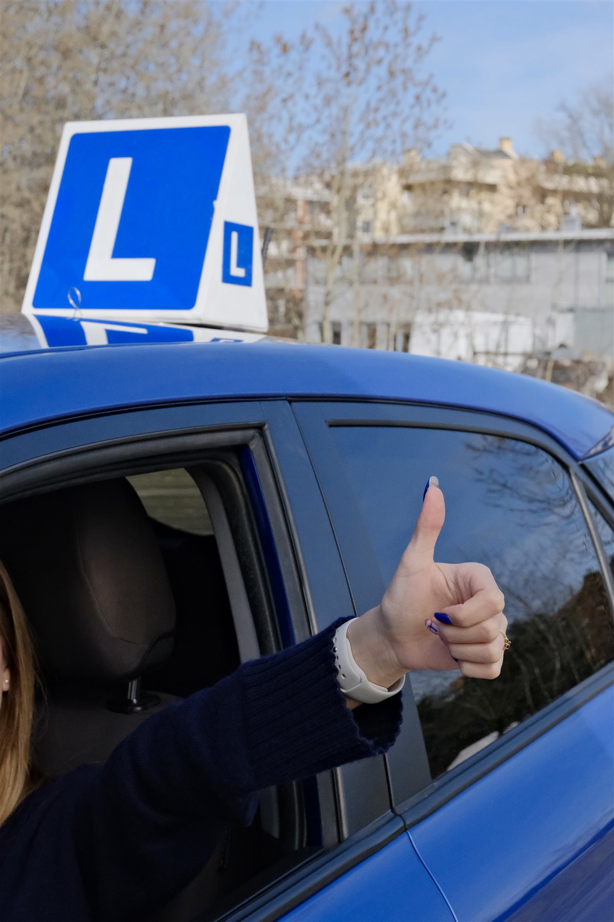 Kursantka z kciukiem w górę po kursie prawa jazdy — Pan Instruktor Warszawa